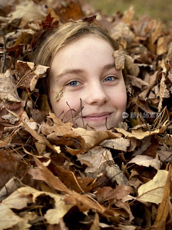 少女的笑脸，从树叶堆中冒出来。