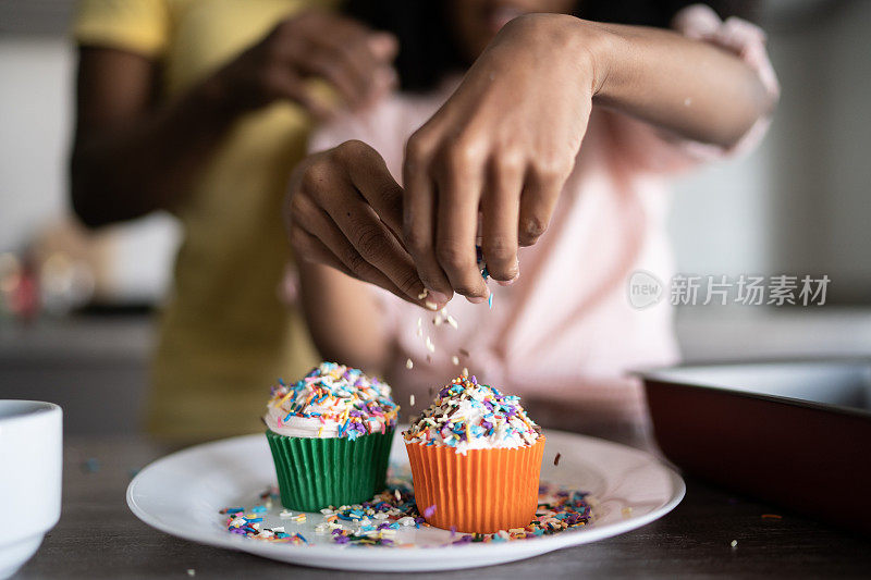 女孩在家里装饰纸杯蛋糕