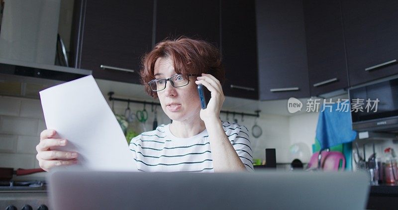 一个在厨房餐桌上工作的成熟女人的肖像