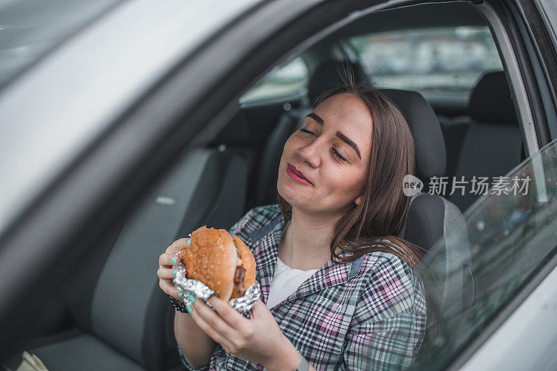 一个女人喜欢在车里吃汉堡