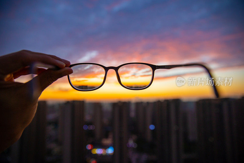 透过眼镜看城市的日落