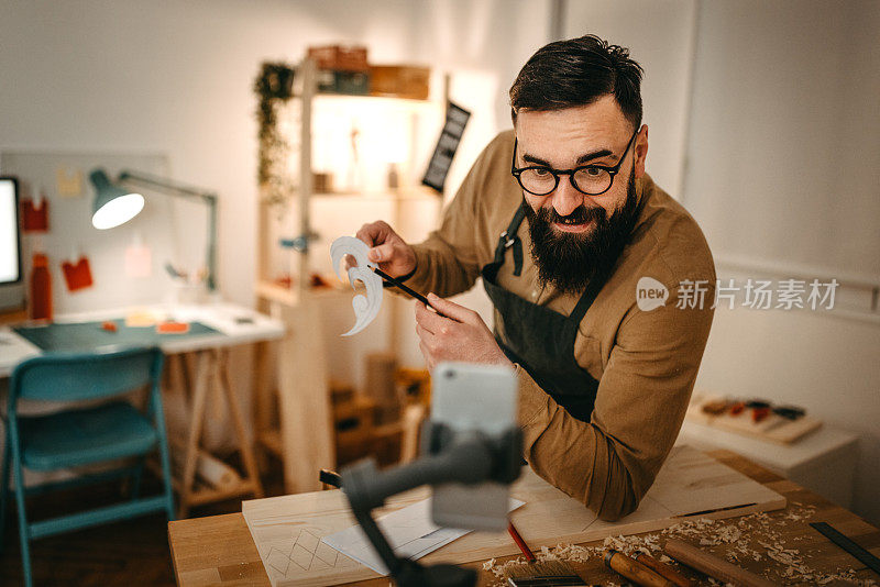 手工艺人展示印刷纸，而在工作室视频博客