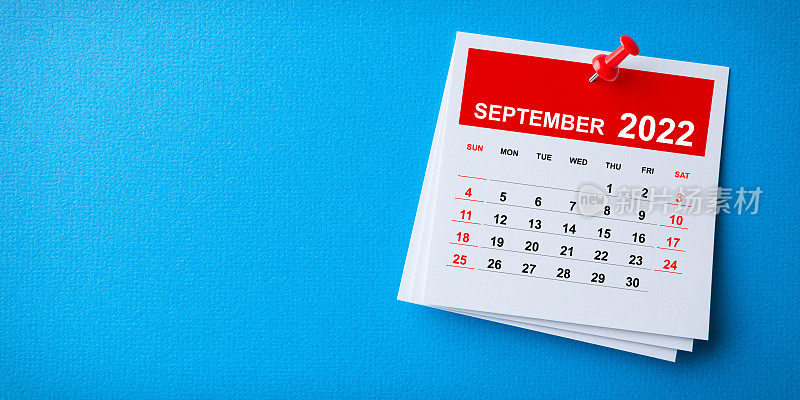 白色便利贴与2022年9月日历和红色图钉在蓝色背景