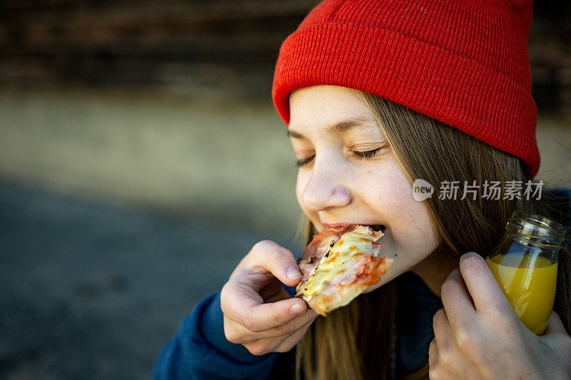 十几岁的女孩在户外吃披萨