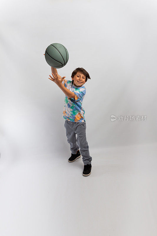 快乐的男孩玩篮球白色的背景