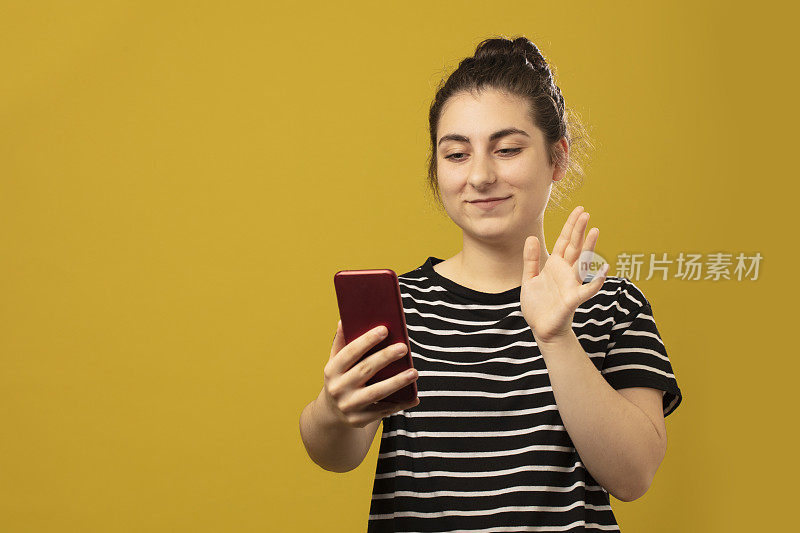 一个年轻漂亮的女孩使用智能手机的特写肖像