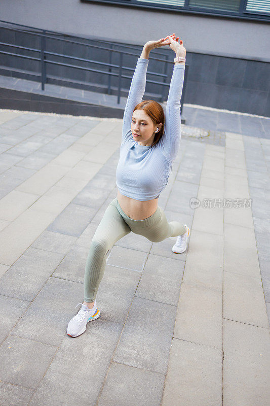 一个年轻的健身女性的肖像站立和伸展腿