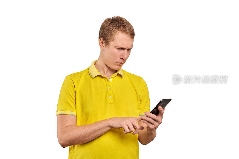 困惑的年轻人用智能手机轻敲触屏，穿着t恤衫的男人孤立在白底