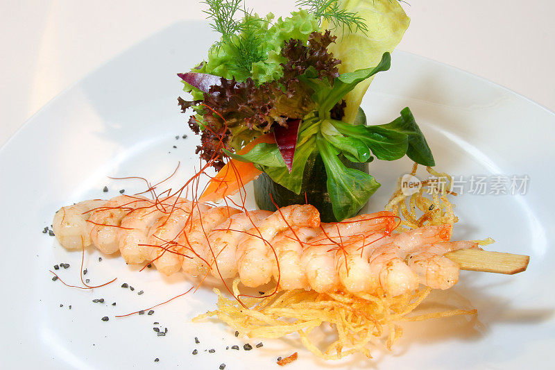 串上大虾，用生菜、土豆和辣椒线装饰
