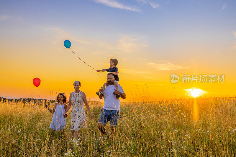 日落时分，快乐的父母带着孩子在草地上探险