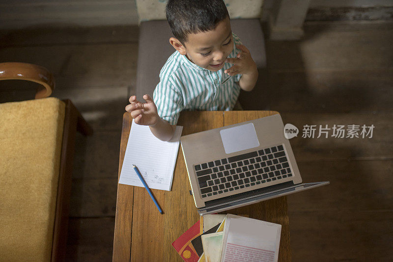 这个孩子正认真地用笔记本电脑学习