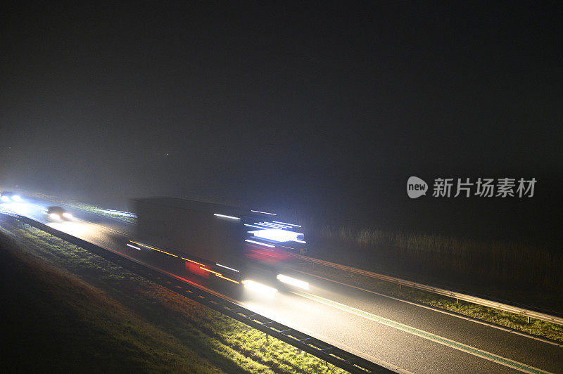 在冬天有雾的黑夜中行驶在道路上的车辆