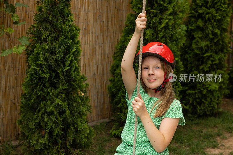 年轻的白人女孩戴着安全帽荡秋千