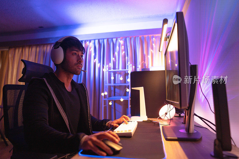 年轻的亚洲男性电子竞技玩家在房间里玩令人兴奋的在线游戏