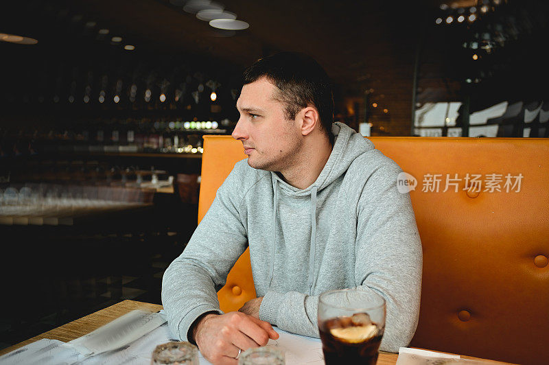 一个男人坐在餐厅里的画像。