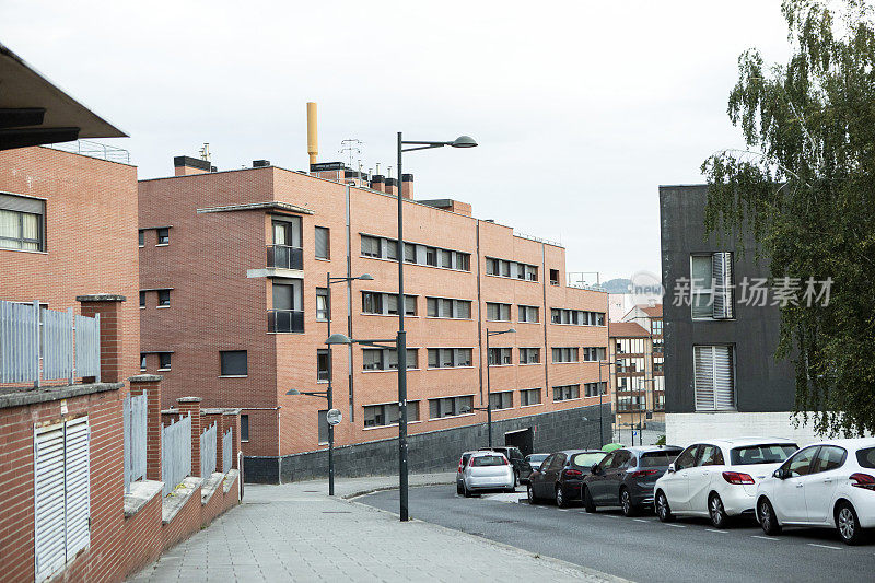 西班牙城市郊区停放的汽车和现代化的公寓楼