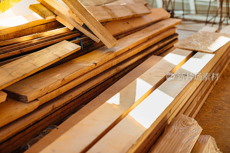 在一栋在建的木屋里，木梁堆放在地板上。