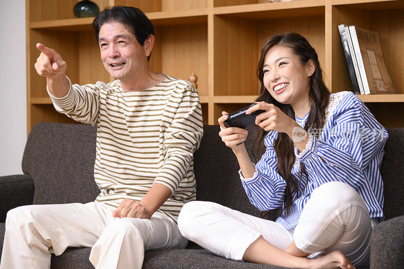 父亲和女儿在玩电子游戏