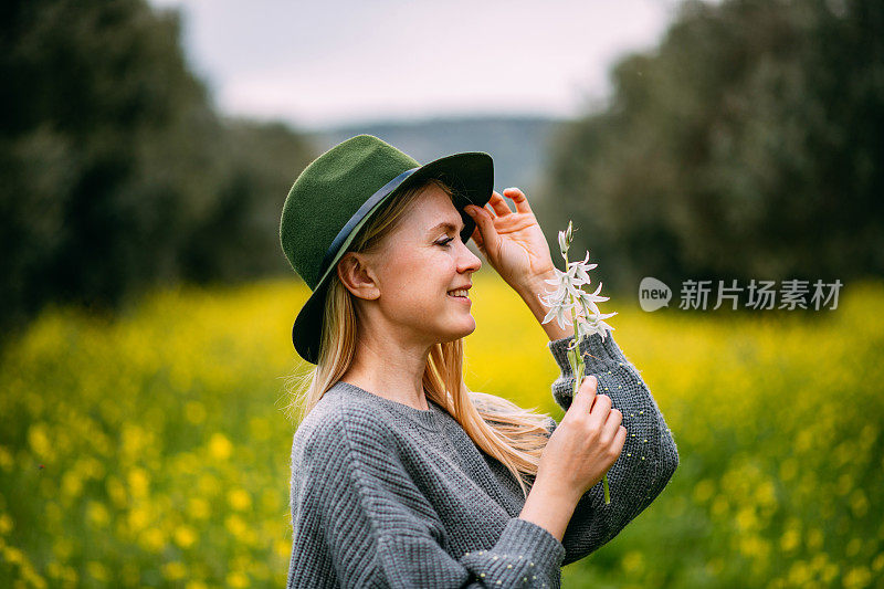 美丽的年轻女子手持春天的花朵