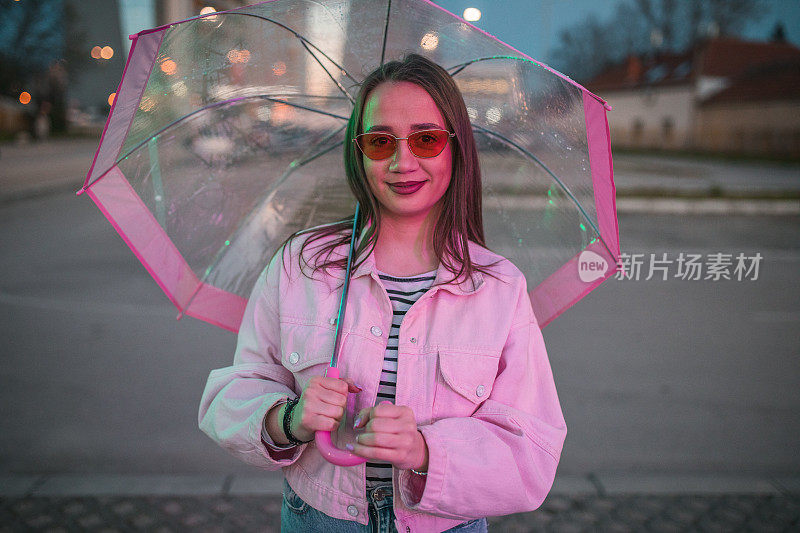 一个可爱的女人在雨夜撑伞散步的肖像