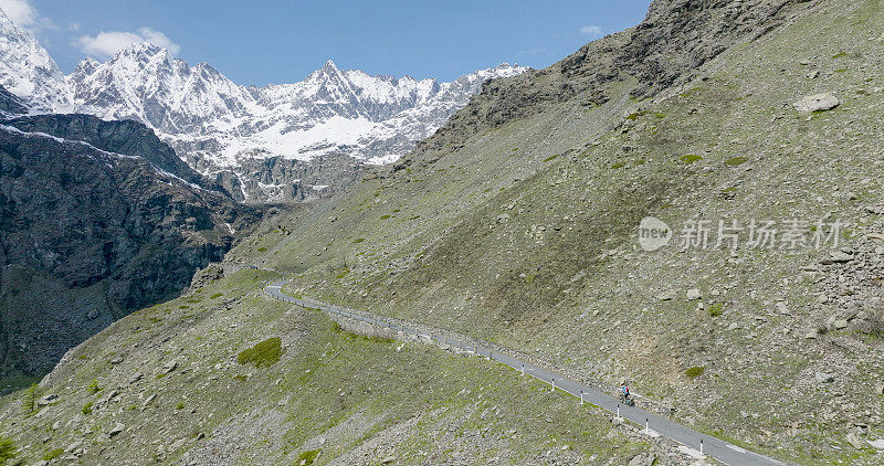 女骑自行车者攀登山路的鸟瞰图