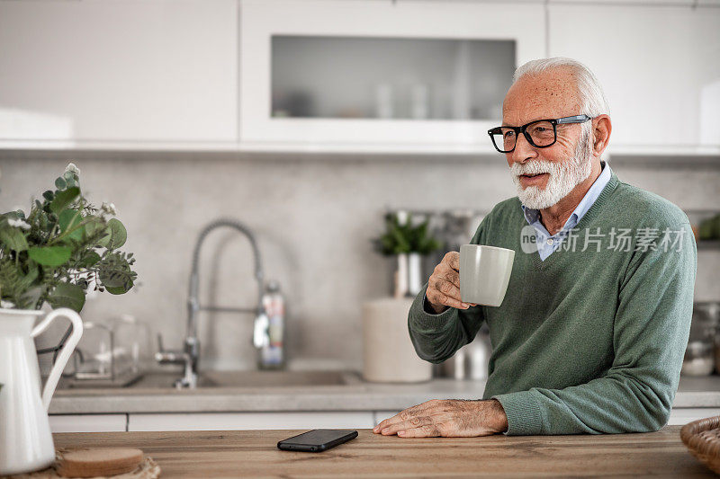 老人，领养老金的人，坐在厨房里开心地笑着，喝着热咖啡或茶，早晨的例行程序，无忧无虑的退休日子