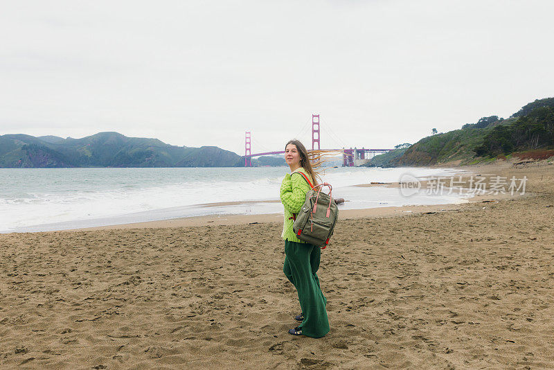 背着背包的女人在加利福尼亚旧金山的贝克海滩沉思