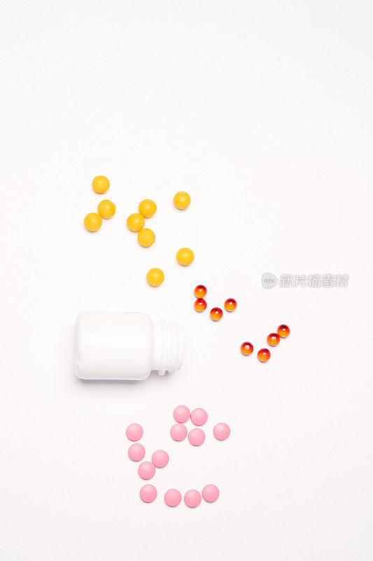 一个装有多种颜色药丸的罐子，在浅色背景上按一定顺序排列