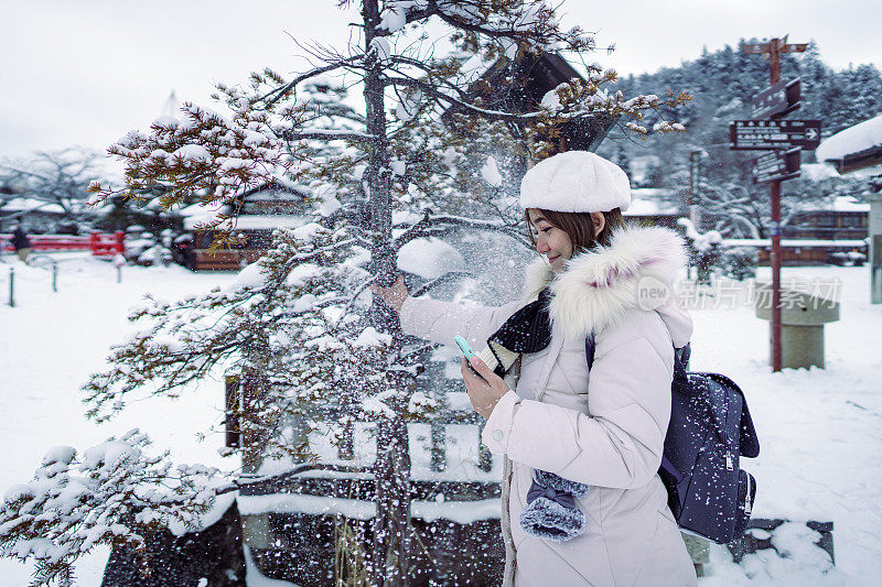 美丽的女游客享受他们的日本之旅在雪的冬天