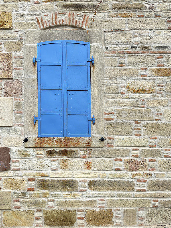 古老的石头房子窗户，蓝色的金属百叶窗