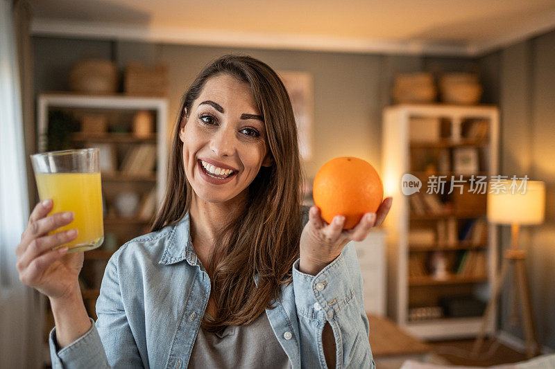 一位年轻女子享受着喝鲜橙汁的时刻