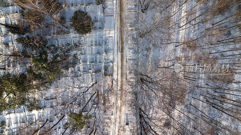 无人机拍摄的一个大墓地在森林覆盖雪在冬天的一天