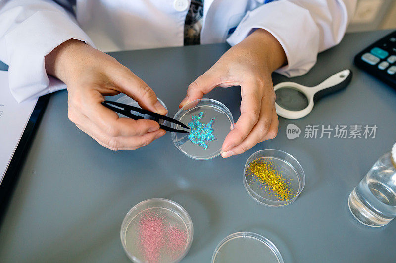 无法辨认的女性化学技师在实验室检查面霜样品中的蓝色闪光