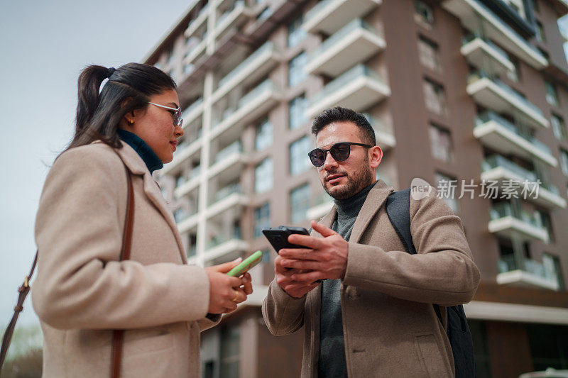 女商人和商人都在使用手机