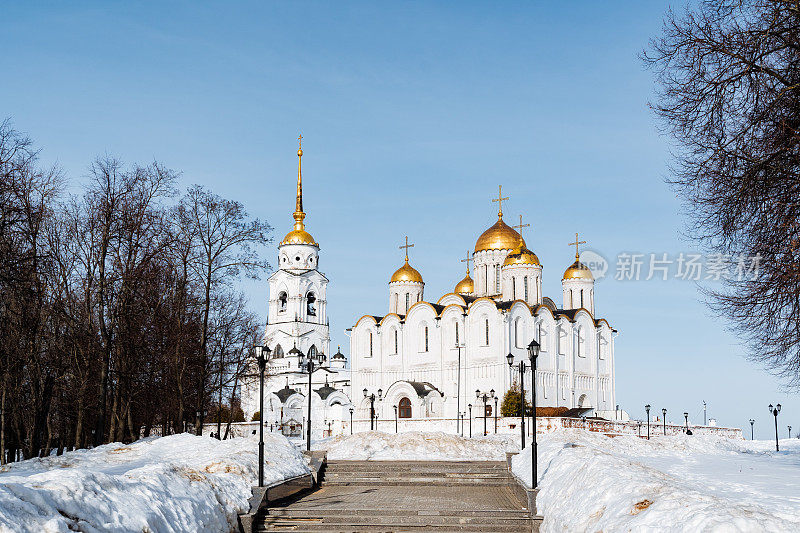 俄罗斯弗拉基米尔的圣母升天大教堂，一座以蓝天为背景的白色石头建造的东正教教堂，教堂上有金色的圆顶。