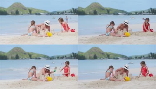 家庭在热带白色沙滩上建造沙堡。父亲和两个女孩在热带海滩上玩沙子高清在线视频素材下载