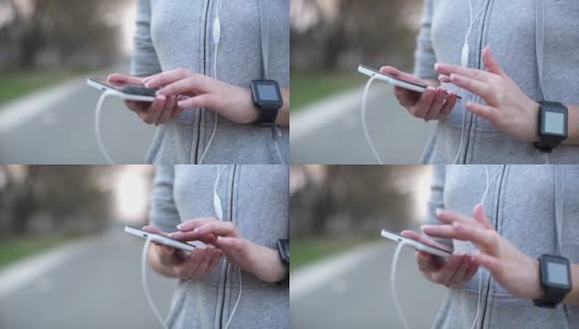 女人用智能手机跑步，通过耳机听音乐。慢动作高清在线视频素材下载