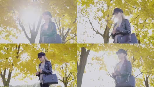 秋日里，体贴的金发美女漫步在公园里，拿着胸前泛黄的枫叶，翘起镜头高清在线视频素材下载