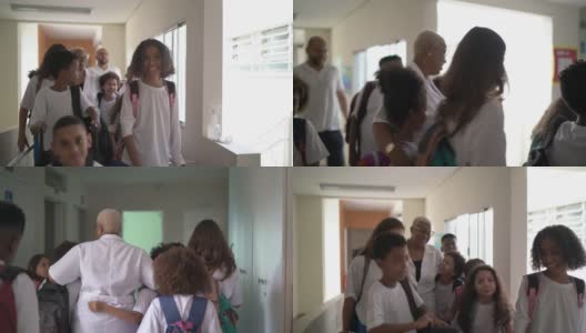 小学生们走在学校走廊上，拥抱老师高清在线视频素材下载