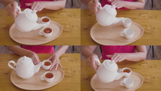 女子从茶壶倒进木桌上的茶杯中，茶道概念高清在线视频素材下载