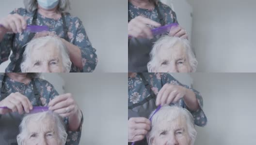一位专业护理发型师在家中理发或洗发时为一位年长的白种妇女梳头高清在线视频素材下载