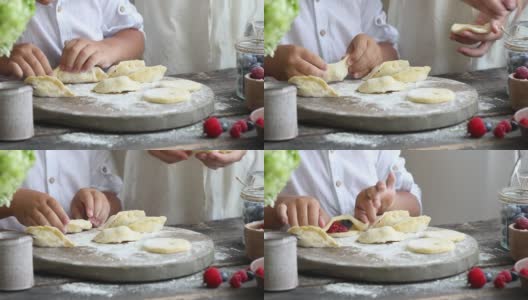 用妇女和儿童的手自制饺子的过程。Pierogi或varenyki高清在线视频素材下载