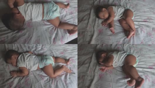 婴儿躺在床上，睡觉时打哈欠伸懒腰，正要醒来。前视图。高清在线视频素材下载