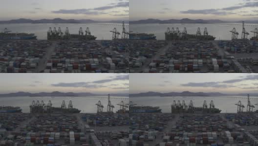 日落之后的海港码头上，卡车仍在密集的集装箱间忙碌穿梭高清在线视频素材下载