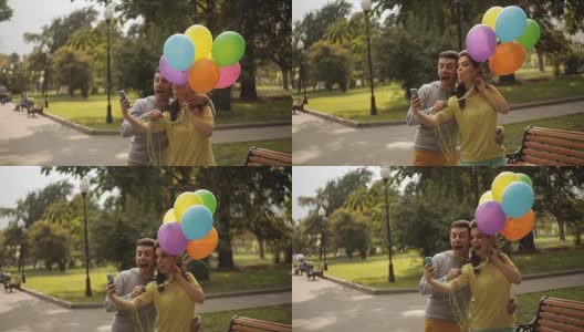 这对情侣在公园里和气球一起自拍高清在线视频素材下载