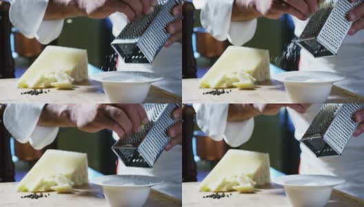 一个厨师磨碎的帕玛森奶酪，典型的意大利奶酪，在盘子里刚刚酿造。高清在线视频素材下载