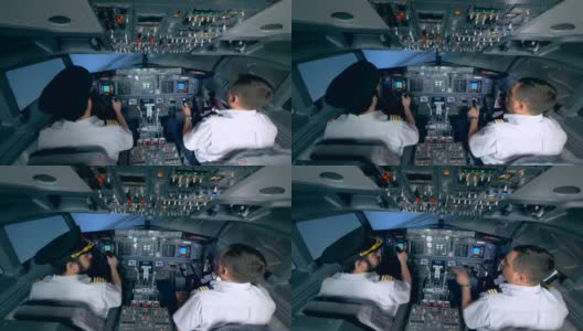 两名飞行员在飞行模拟器中操纵飞机。高清在线视频素材下载