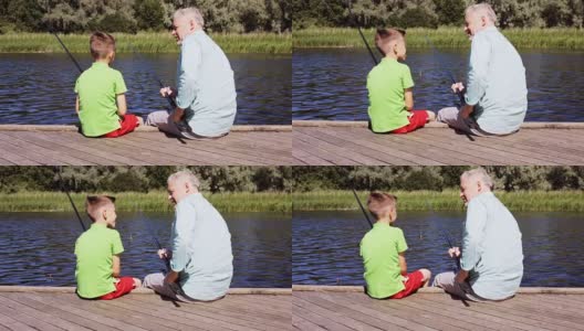 快乐的爷爷和孙子在河边钓鱼高清在线视频素材下载