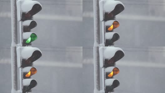 暴风雪期间，雪中的红绿灯控制交通。龙卷风来临时，大雪使道路上汽车的行驶变得复杂。特写镜头高清在线视频素材下载