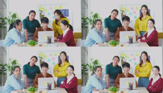 描绘快乐亚洲商业，创意企业家团队会议和头脑风暴在办公室，亚洲青年团队合作伙伴的微笑和看着相机高清在线视频素材下载